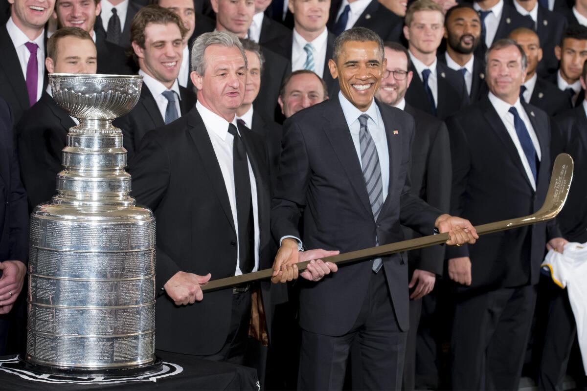 President Obama smiles while posing with Kings Coach Darryl Sutter during a ceremony at the White House to honor the 2014 Stanley Cup Champions.