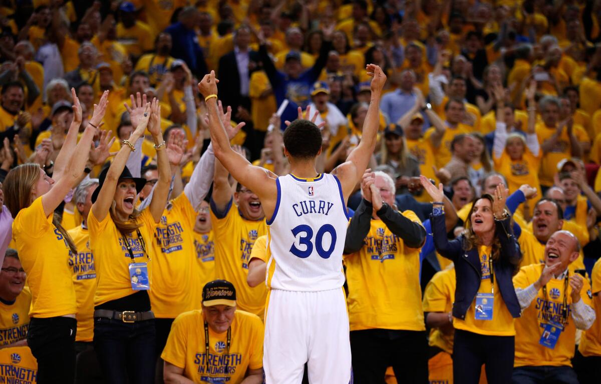 Golden State guard Stephen Curry gestures to the crowd after making a basket during the fourth quarter of the Warriors' 99-98 win over the Houston Rockets in Game 2 of the Western Conference finals.