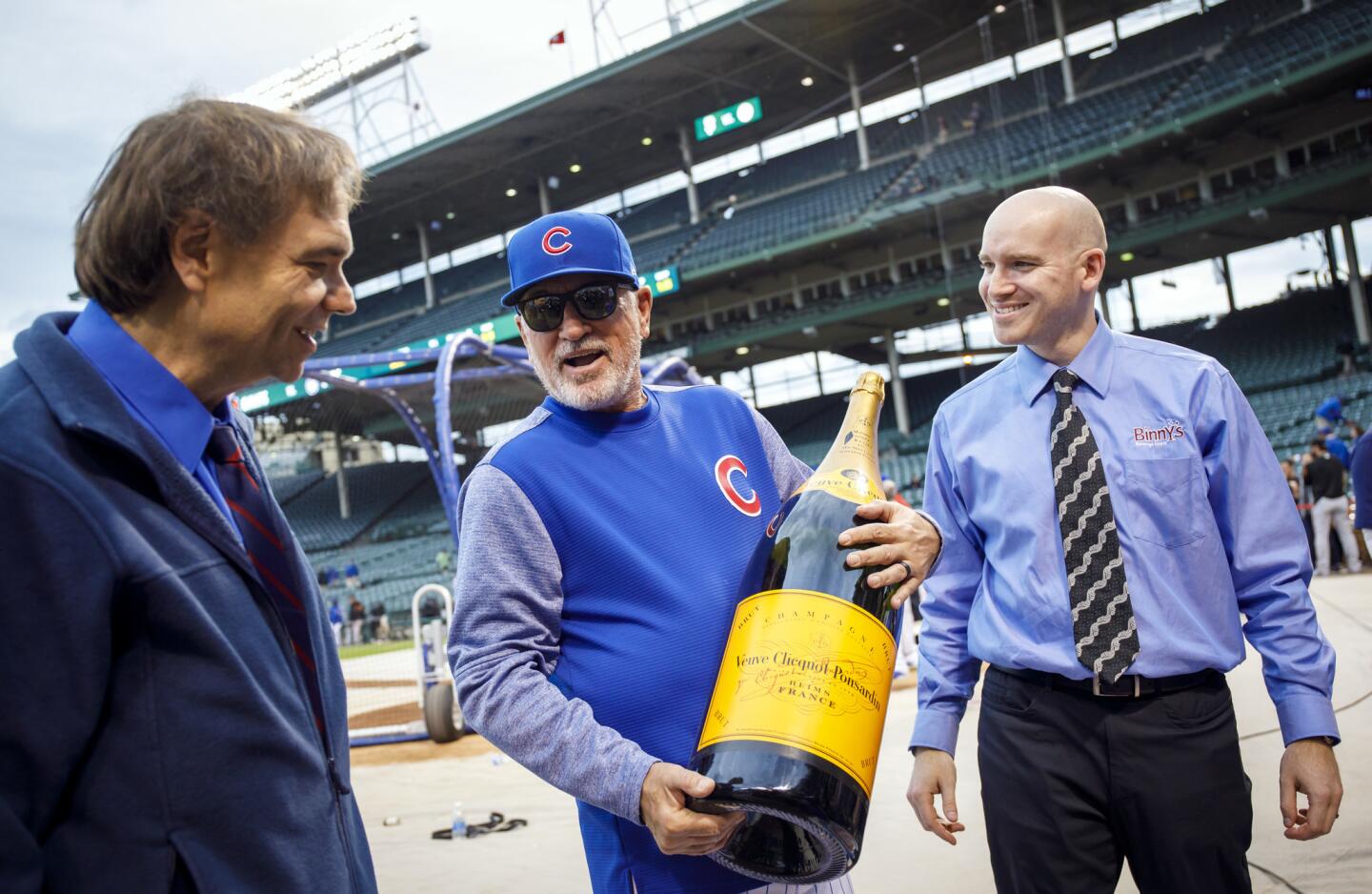 Cubs manager Joe Maddon holds a 15-liter "Nebuchadnezzar" bottle of champagne as part of a pre-game promotion Monday, May 22, 2017, at Wrigley Field.