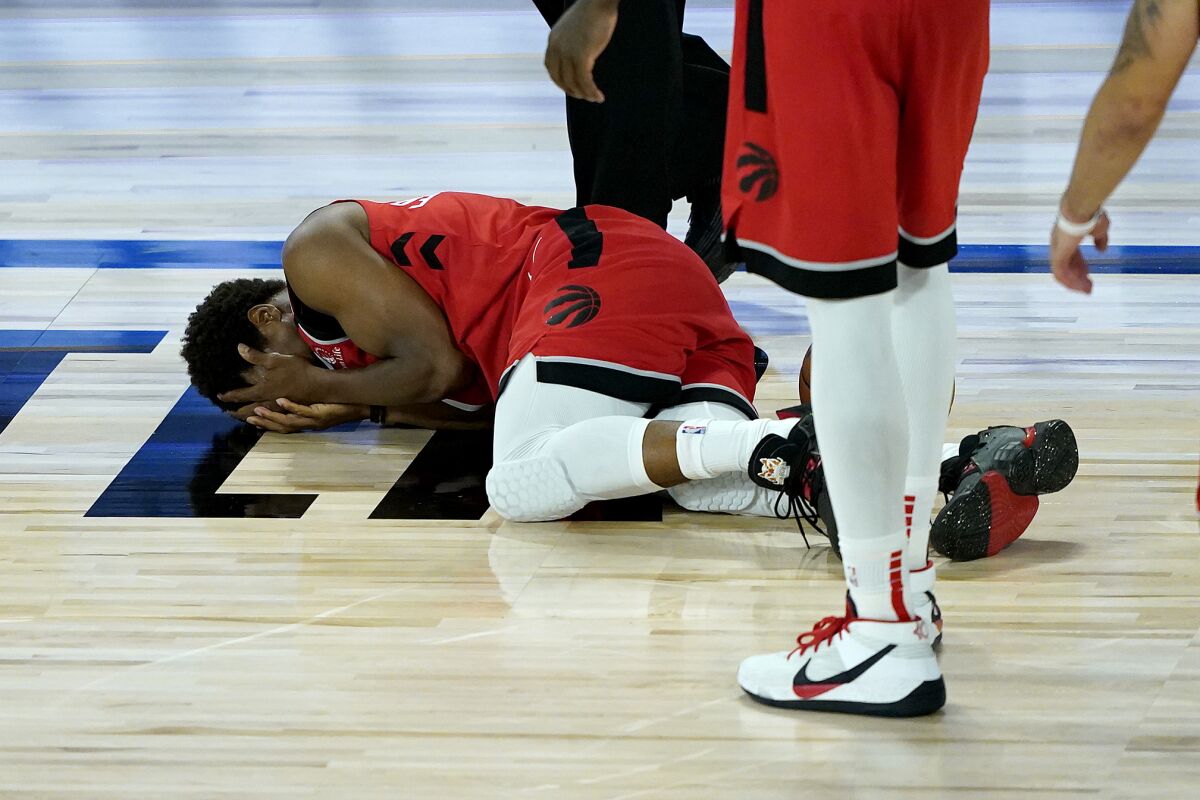 Toronto Raptors' Kyle Lowry lies on the court after being hit in the face during the second half of an NBA basketball game against the Miami Heat Monday, Aug. 3, 2020, in Lake Buena Vista, Fla. (AP Photo/Ashley Landis, Pool)