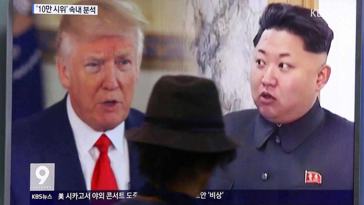 A South Korean watches a TV screen showing President Trump and North Korean leader Kim Jong Un.