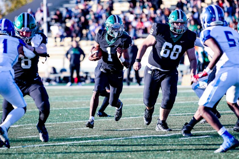 Dijon Stanley of Granada Hills prepares to take off behind the blocking of Phyllip Hamburg-Martinez.