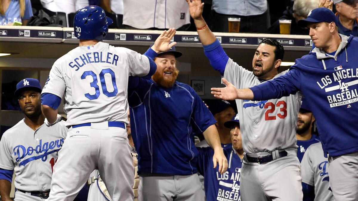 Dodgers right fielder Scott Schebler (30) is congratulated in the dugout by teammates after hitting a solo home run against the Padres in the second inning Friday night in San Diego.