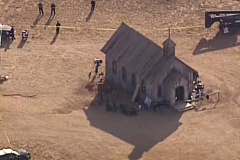 Esta imagen aérea, cortesía de KOAT 7 News, muestra a agentes del Departamento de Policía del condado Santa Fe que acudieron al lugar tras una muerte por disparo de arma de fuego, el jueves 21 de octubre de 2021, en un set de filmación de Bonanza Creek, cerca de Santa Fe, Nuevo México. (KOAT 7 News vía AP)