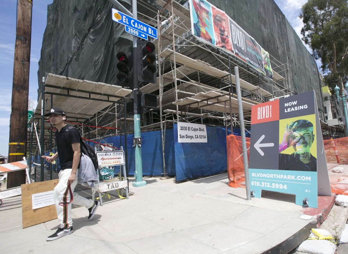 A man walked past "The Boulevard" development project which was under construction in North Park in 2019. 