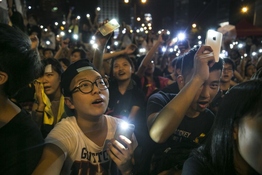 Student protesters hold their cell phone lights while chanting pro democracy slogans at the protest site in Hong Kong.