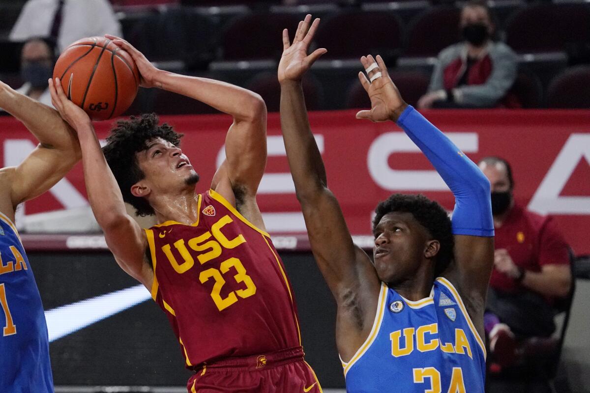 USC forward Max Agbonkpolo shoots over UCLA guard David Singleton.