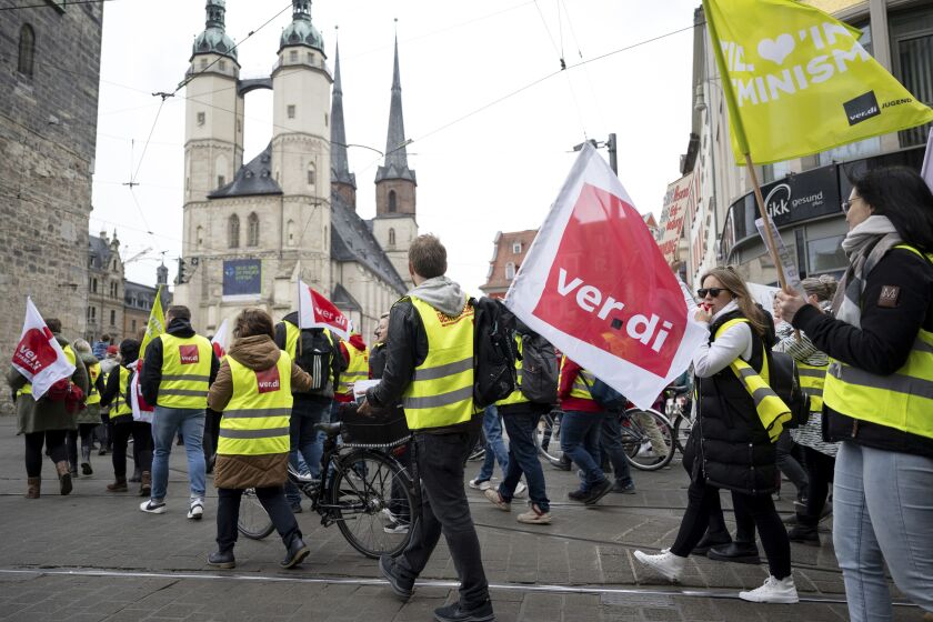 Demonstrators march through downtown Halle/Saale, Germany, Thursday, March 23, 2023. German unions are calling on thousands of workers across the country's transport system to stage a one-day strike on Monday that is expected to bring widespread disruption to planes, trains and local transit. (Hendrik Schmidt/dpa/dpa via AP)