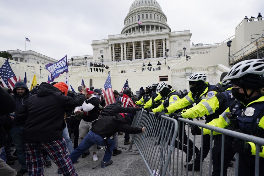 FILE - In this Jan. 6, 2021 file photo, rioters try to break through a police barrier at the Capitol in Washington. People charged in the attack on the U.S. Capitol left behind a trove of videos and messages that have helped federal authorities build cases. In nearly half of the more than 200 federal cases stemming from the attack, authorities have cited evidence that an insurrectionist appeared to have been inspired by conspiracy theories or extremist ideologies, according to an Associated Press review of court records. (AP Photo/Julio Cortez, File)