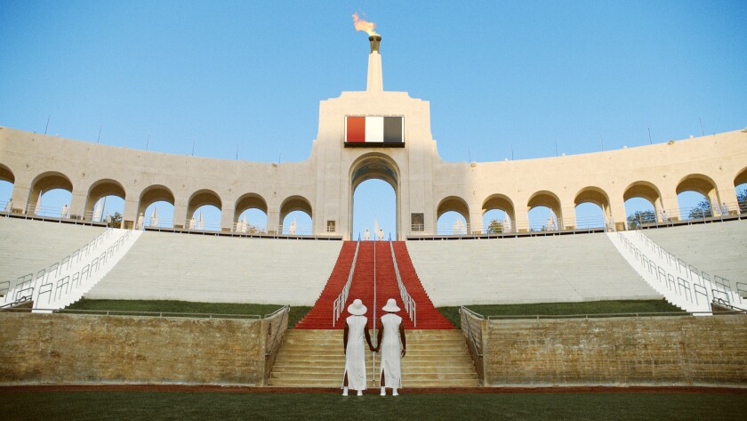 The backdrop of the Los Angeles Coliseum with two models.