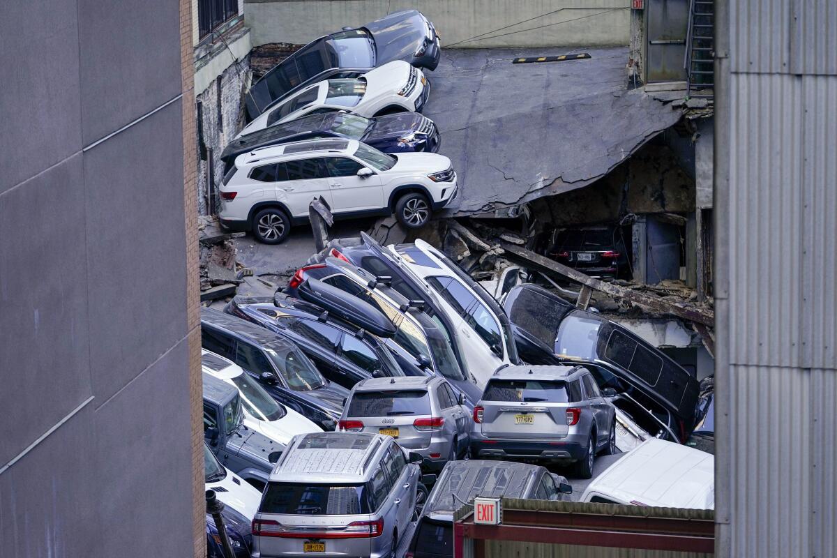 Autos apilados tras el derrumbe parcial de una estructura de estacionamiento