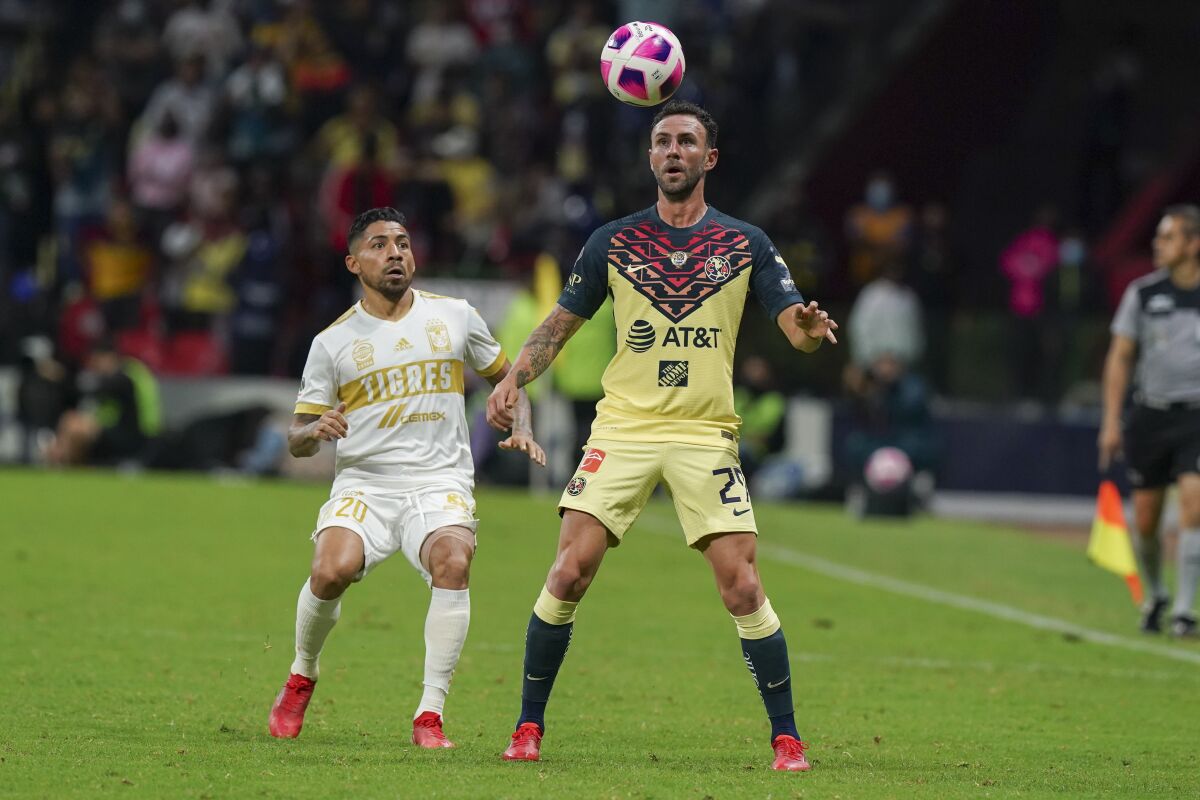 America's Miguel Layun, center, and Tigres' Javier Aquino go for the ball during a Liga MX match 