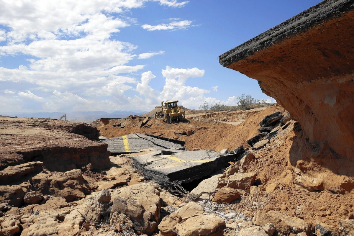 A bulldozer works on a flood-ravaged portion of Interstate 15 near Moapa, Nev.