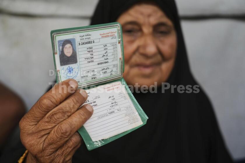 Ghalia Abu Moteir, cuya familia huyó de lo que hoy es Israel durante la guerra de 1948 que dio paso a la creación del Estado israelí, muestra sus documentos en una tienda de campaña en Jan Yunis, Franja de Gaza, después de ser desplazada de su hogar en Rafah, por la actual guerra, el miércoles 14 de mayo de 2025. (AP Foto/Abdel Kareem Hana)