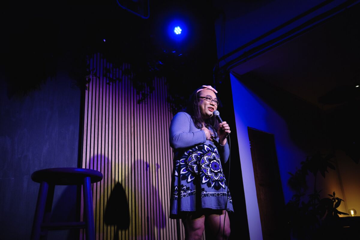 Transgender female comedian on stage under a spotlight