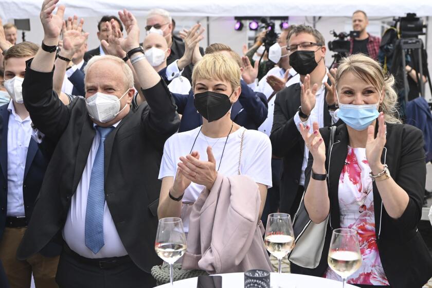 Supporters of Merkel's Christian Democratic Union party, CDU, react after firs exit poll for the Saxony-Anhalt state elections announced in Magdeburg, Germany, Sunday, June 6, 2021. The election for the new state parliament in Saxony-Anhalt was the last state election before the federal election in September 2021. (Bernd Von Jutrczenka/dpa via AP)