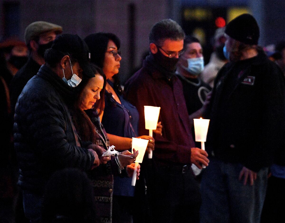 People hold candles as they attend a vigil