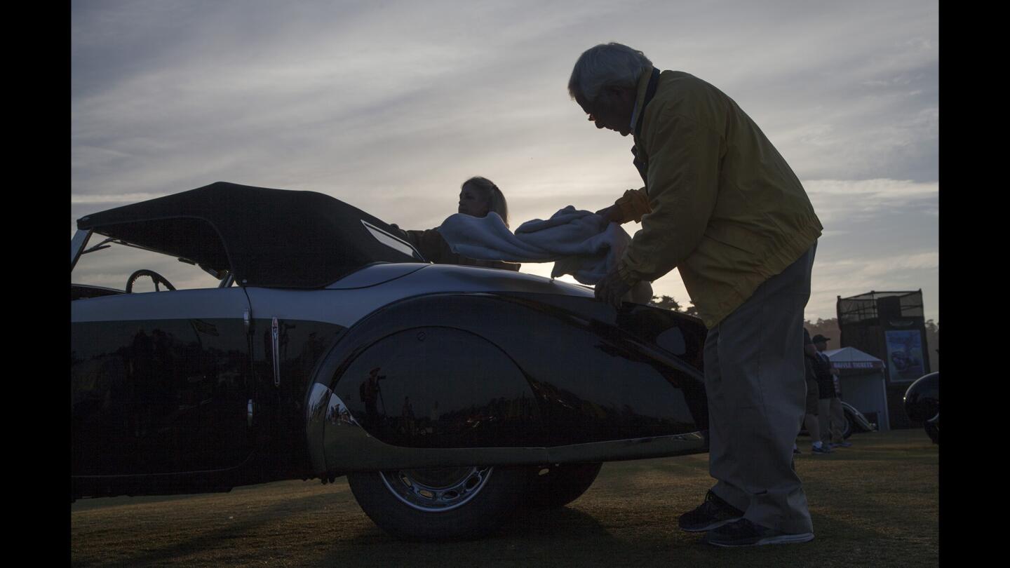 Louis and Abigail Natenshon wipe down their 1937 Peugeot 402 Pourtout Cabriolet ahead of the luxurious Concours d'Elegance classic car competition at Pebble Beach on Sunday.
