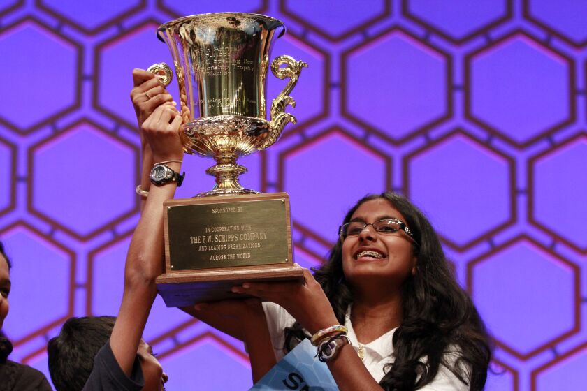 Snigdha Nandipati, 14, of San Diego, right, and her brother Sujan Nandipati, hoist up her trophy after she won the National Spelling Bee with the word "guetapens" in Oxon Hill, Md., on Thursday, May 31, 2012. (AP Photo/Jacquelyn Martin)