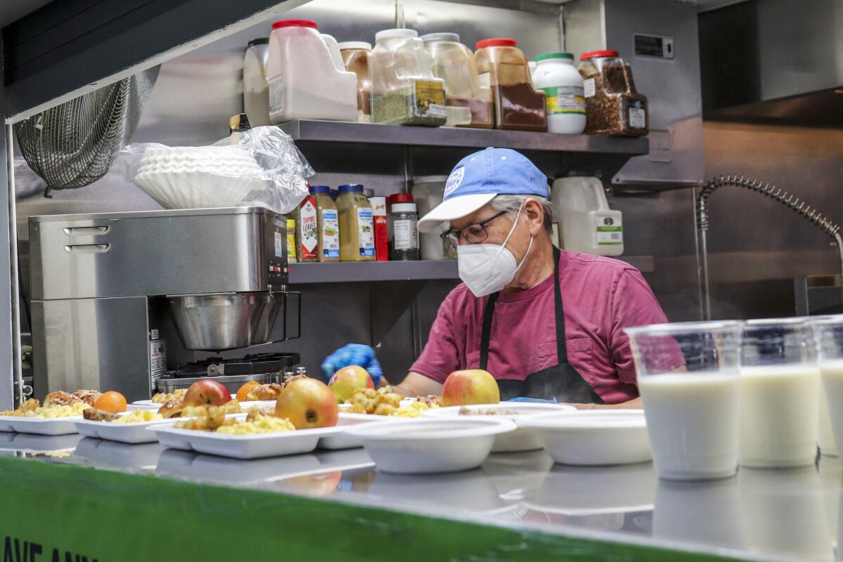 A volunteer with Union Station Homeless Services examines prepared meals