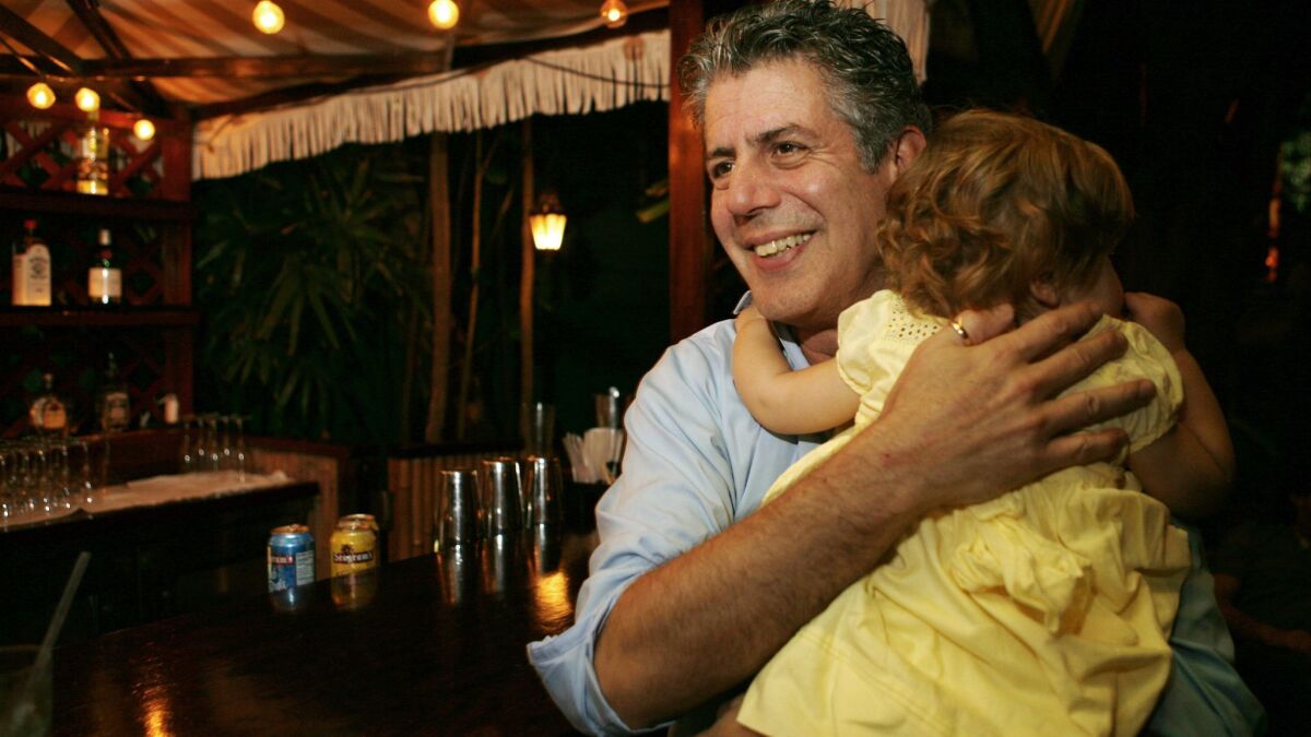 Anthony Bourdain holds his daughter Ariane in Miami Beach on Nov. 12, 2008. Court papers show that Bourdain was worth $1.2 million when he died last month. He left most of his estate to his daughter, who is now 11.
