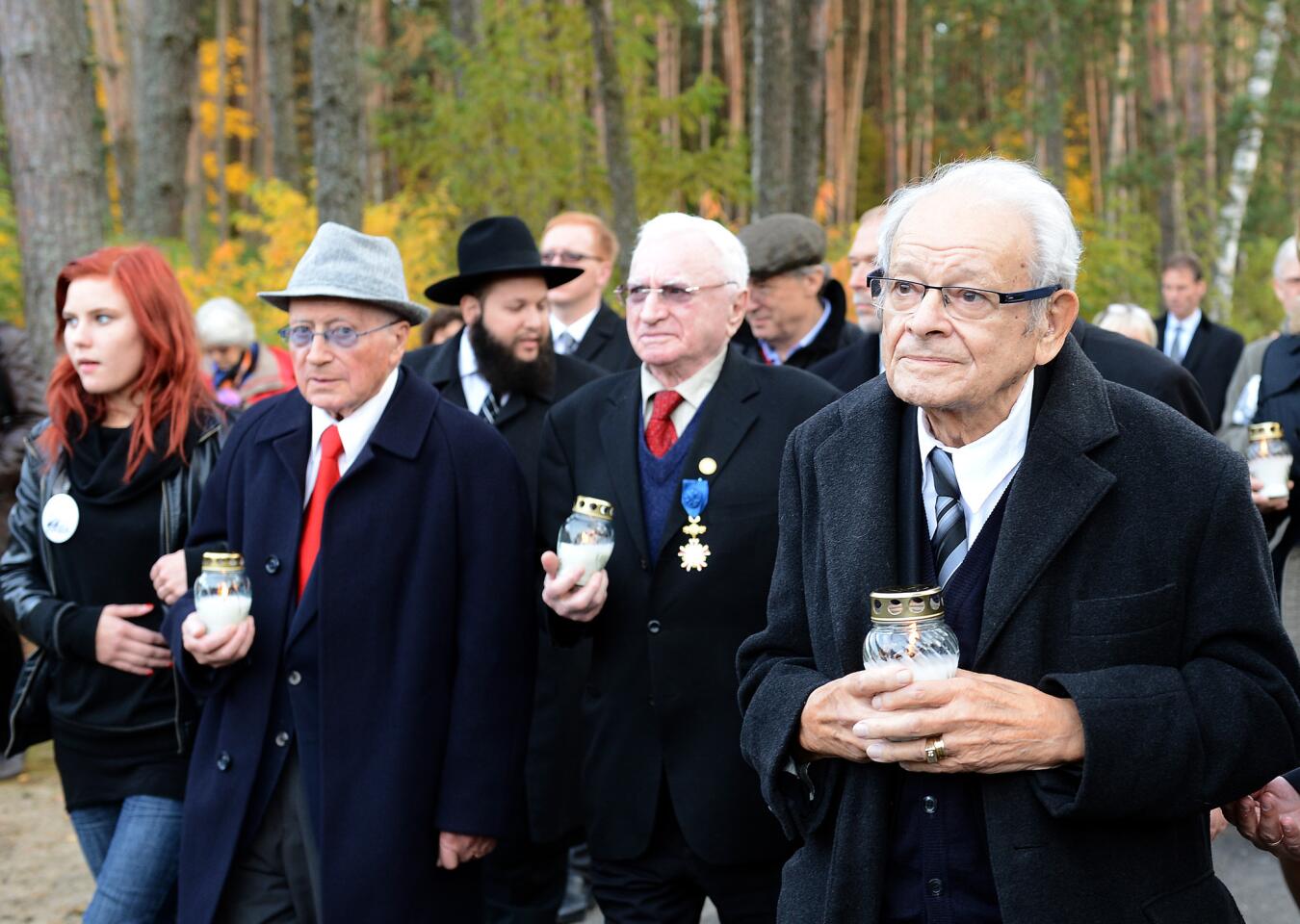 During a 2013 ceremony commemorating the 70th anniversary of a successful uprising at the Sobibor camp, insurgents Philip Bialowitz, from left, Thomas Blatt and Jules Schelvis light candles.