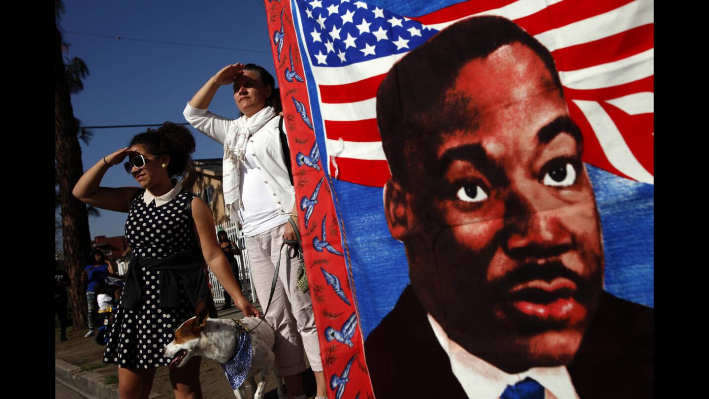 Sequoyah Madison and her mother, Kimberly Madison, shield their eyes from the sun while watching the 30th annual Kingdom Day Parade in Los Angeles on Monday.