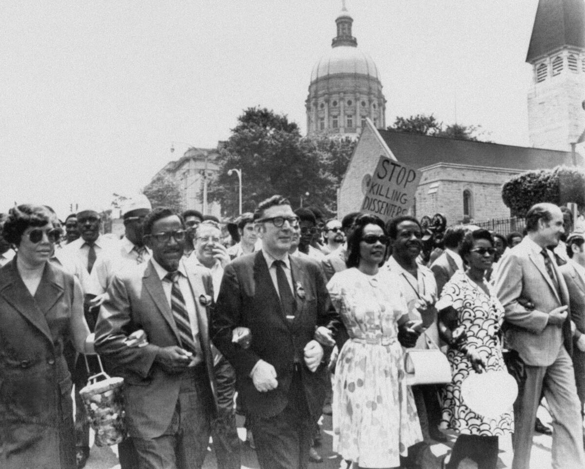 The Rev. Joseph Lowery, second from left, walks with labor leader Leonard Woodcock, center, Coretta Scott King, right, widow of the Rev. Martin Luther King Jr., and several thousand marchers past the state Capitol in Atlanta to protest war, violence and racial repression in May 1970.