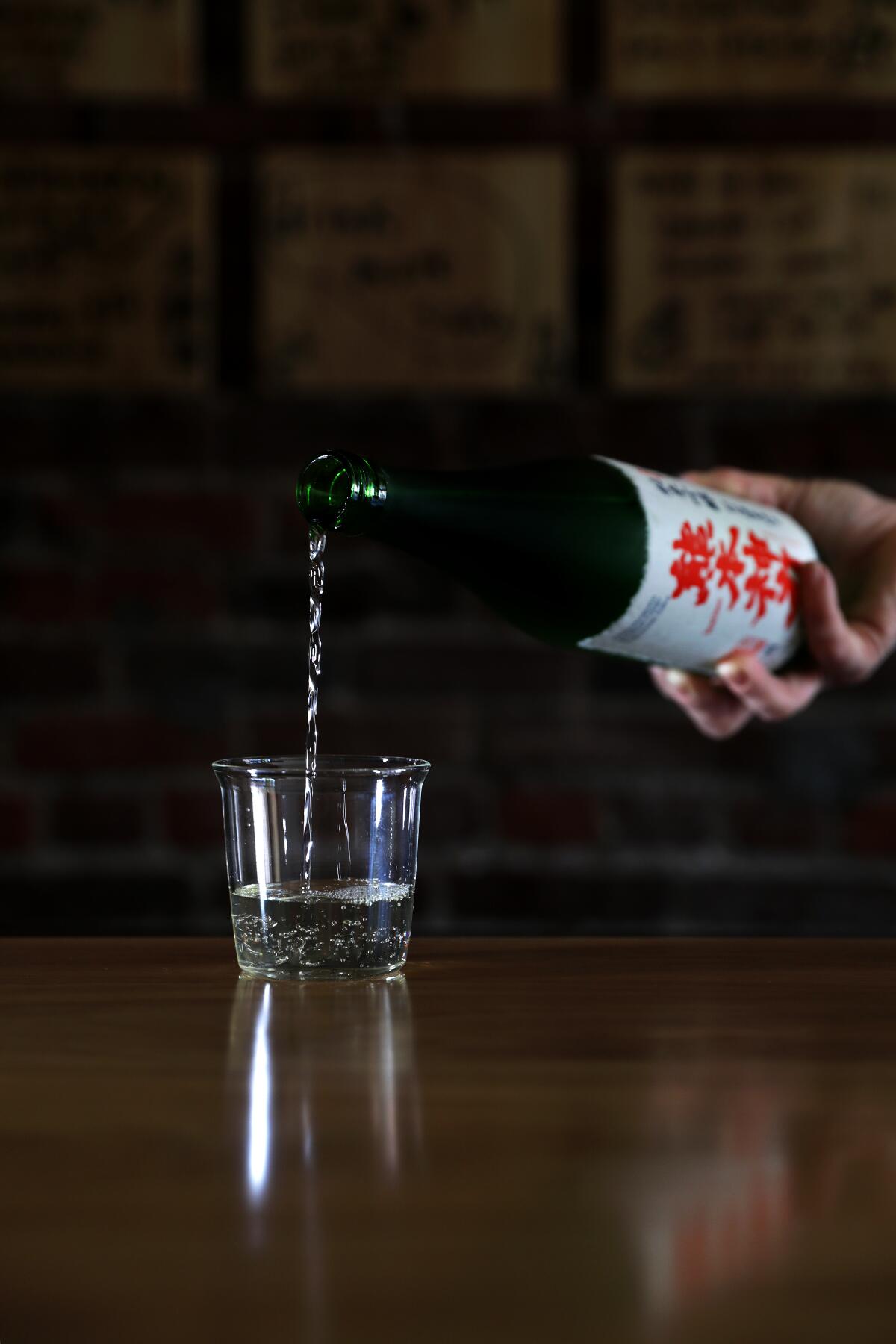 Courtney Kaplan pours a glass of sake