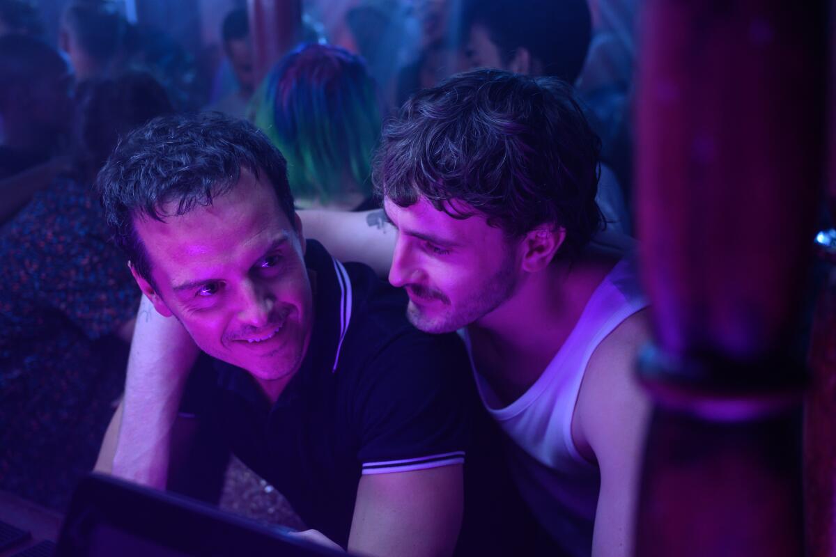 Two men in the purple light of a nightclub