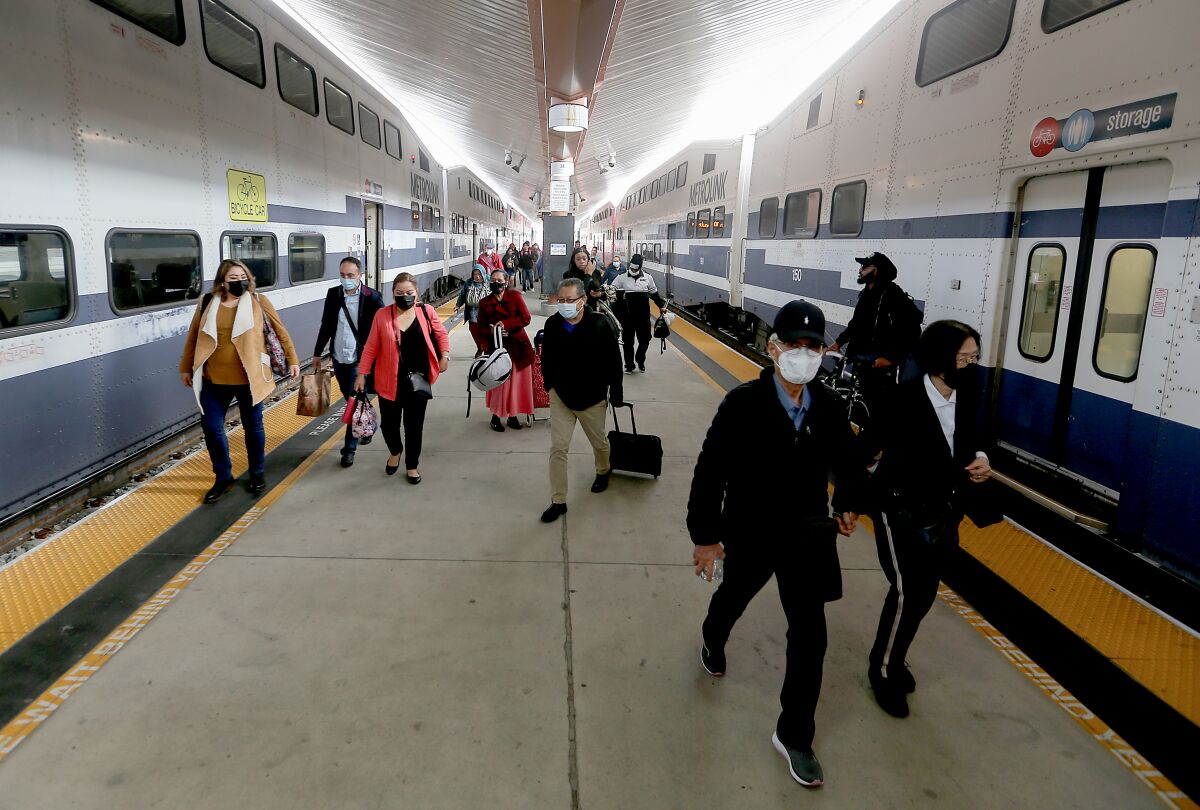 Passengers walk on a platform after arriving by Metrolink train at Union Station in downtown Los Angeles on Monday.