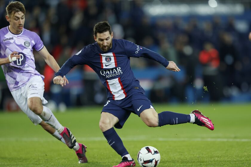 PSG's Lionel Messi, right, kicks the ball next to Toulouse's Anthony Rouault during the French League One soccer match between Paris Saint-Germain and Toulouse, at the Parc des Princes, in Paris, France, Saturday, Feb. 4, 2023. (AP Photo/Lewis Joly)
