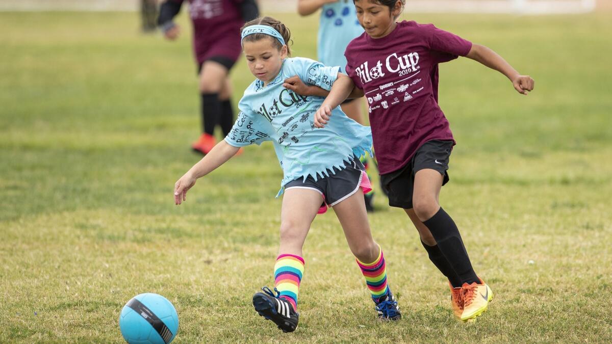 Costa Mesa St. Joachim Catholic School's Cece Ball tries to keep the ball away from Costa Mesa Sonora's Vanessa Zarate in a girls' third- and fourth-grade Bronze Division quarterfinal match at the Daily Pilot Cup on Saturday.