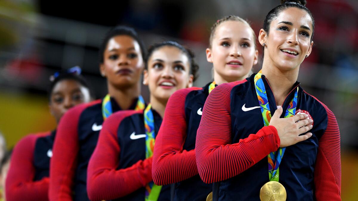 The gold medal-winning U.S. women's gymnastics team listens to the national anthem during the awards ceremony on Tuesday.