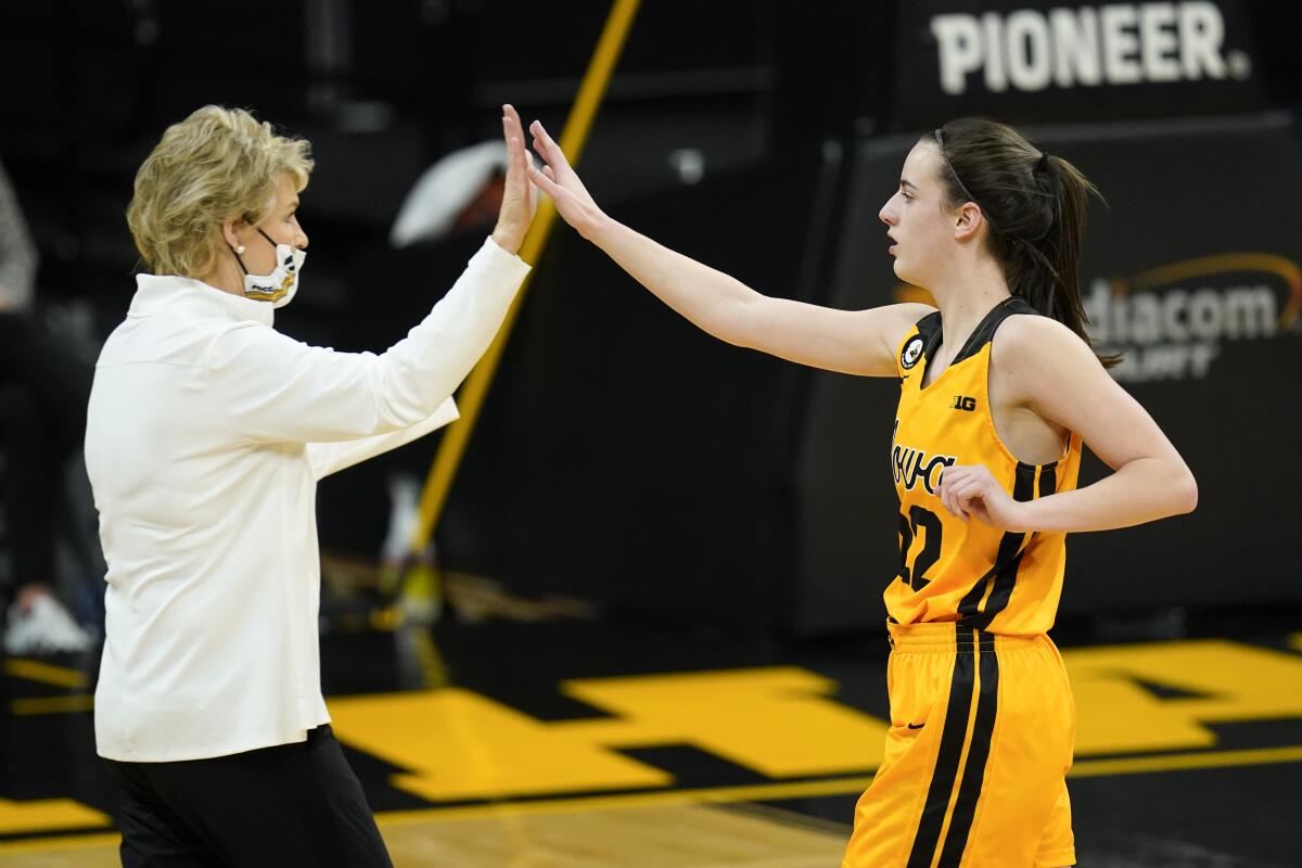 Iowa guard Caitlin Clark, right, celebrates with coach Lisa Bluder during the first half of the team's NCAA college basketball game against Ohio State, Wednesday, Jan. 13, 2021, in Iowa City, Iowa. Clark is fourth in the nation in scoring, fourth in the nation in assists and ninth in assists per game. She is also second on the team in rebounds and tied for the team lead in blocked shots. “She’s not one-dimensional,” Bluder said. (AP Photo/Charlie Neibergall)