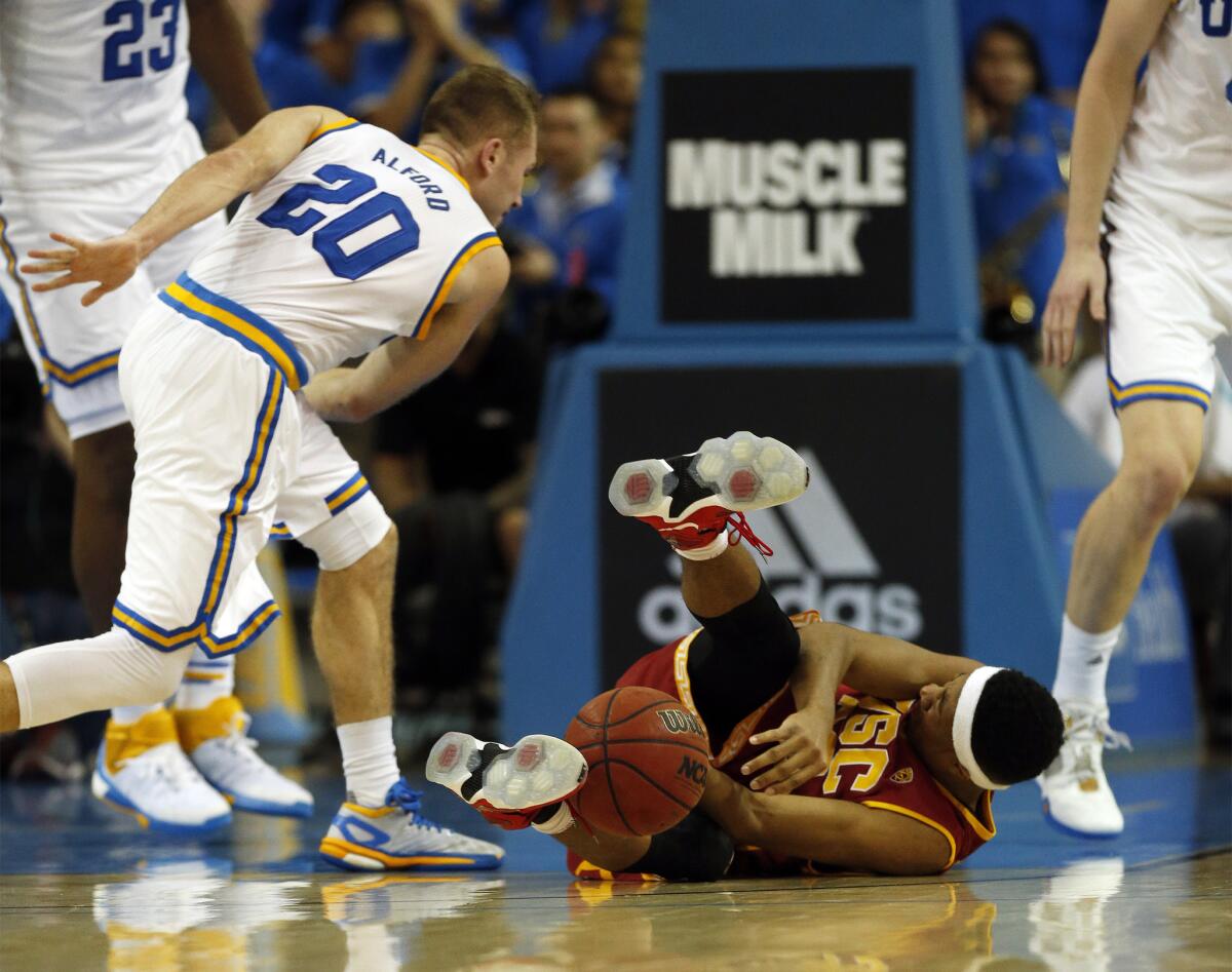 USC guard Elijah Stewart goes to the ground after colliding with UCLA guard Bryce Alford. Both USC and UCLA need big weeks against the visiting Washington schools.