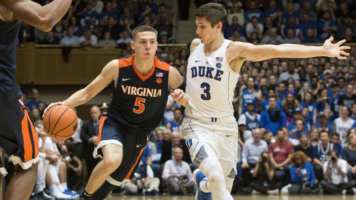Virginia's Kyle Guy (5) handles the ball against the defense of Duke's Grayson Allen (3) during the second half.