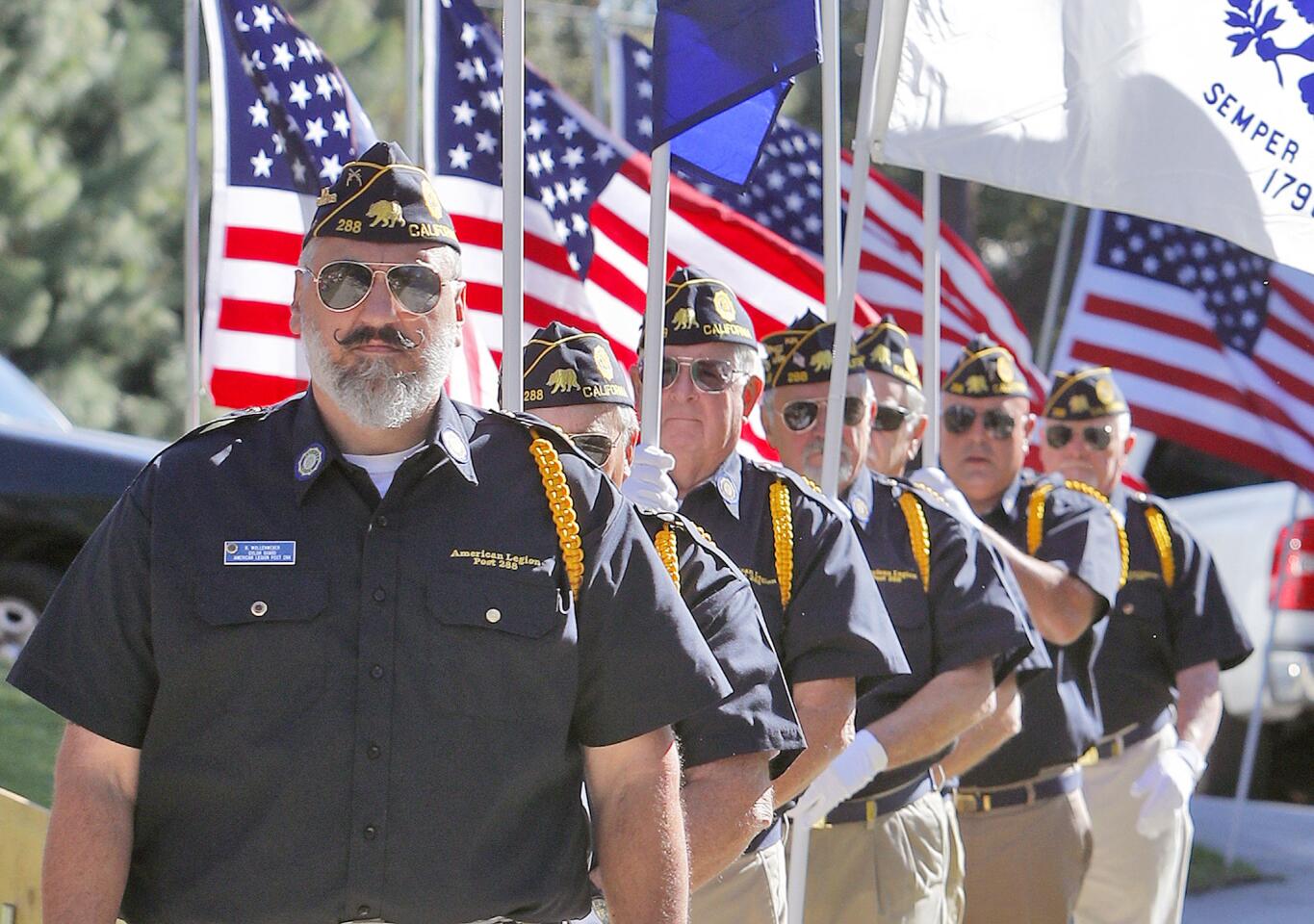American Legionâ€™s Robert Wollenweber leads fellow members who bring flags of the branches of the military to center stage for a brief recognition at Two Strike Park in La Crescenta on Veteran's Day, Monday, November 12, 2018. United States Congressman Adam Schiff briefly spoke, and the Armistice was recognized, as well as each branch of the military. A U.S. Flag was also retired.