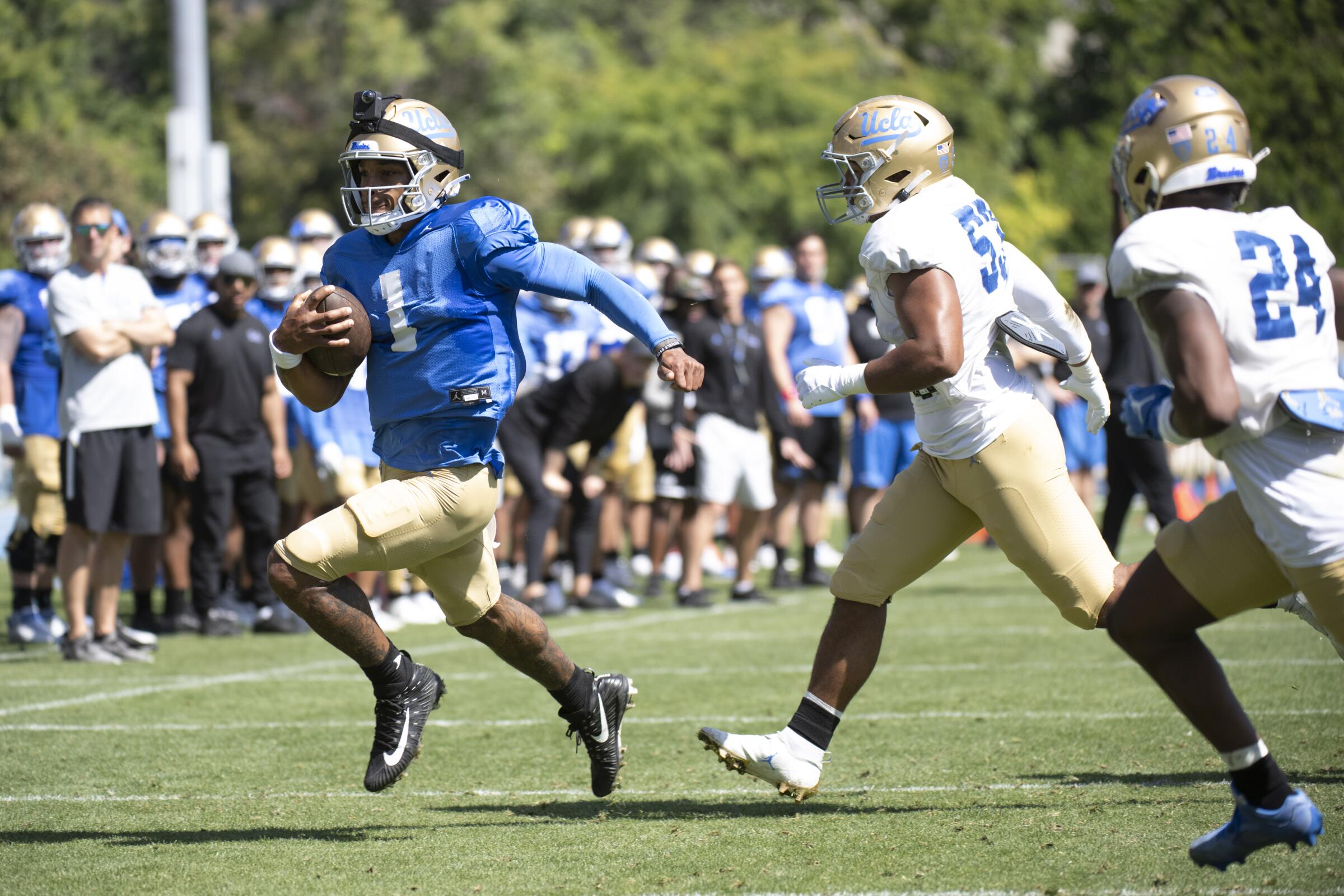 UCLA quarterback Dorian Thompson-Robinson, left, runs with the ball during the Bruins' spring showcase.