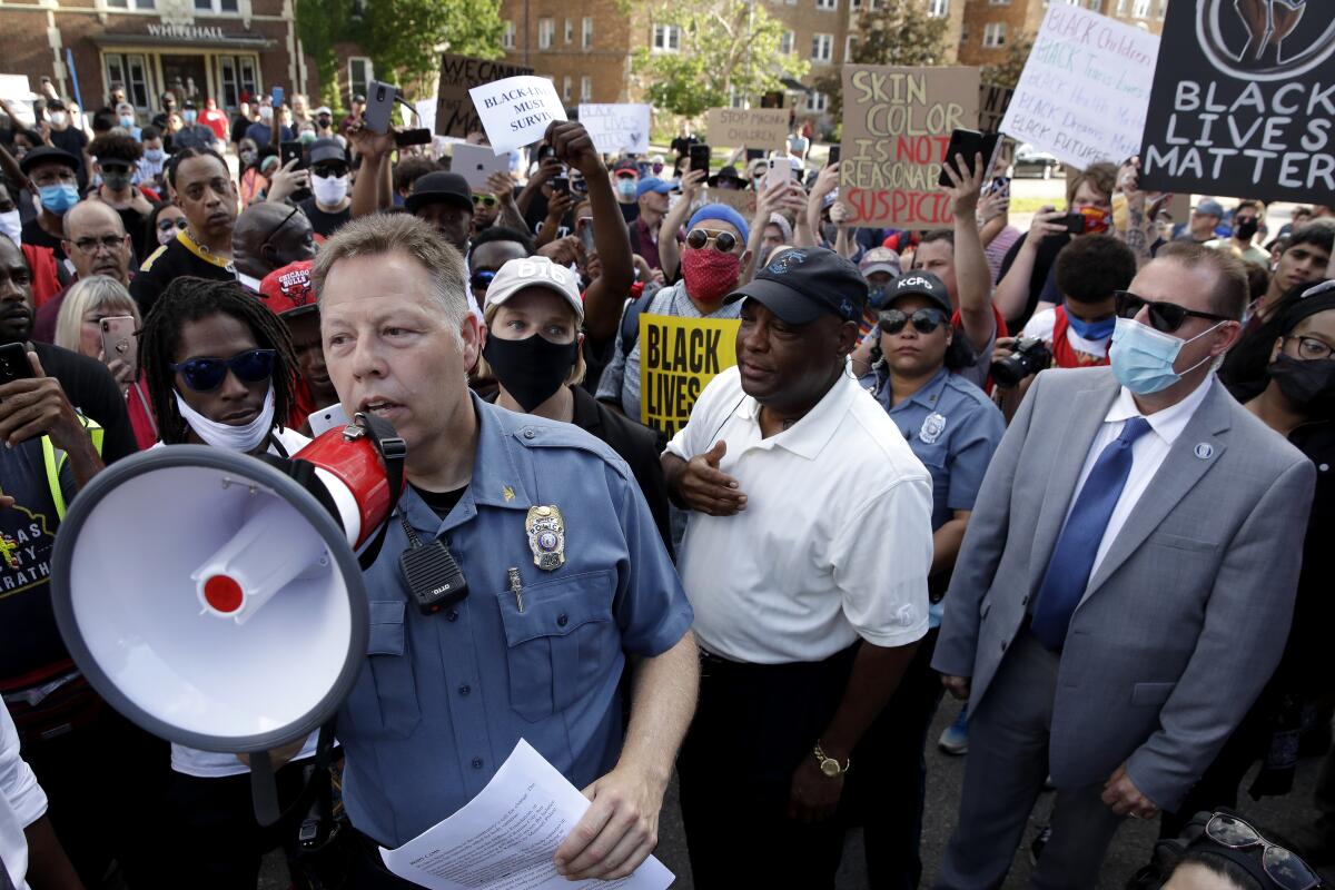 Kansas City Police Chief Rick Smith uses a megaphone to address protesters