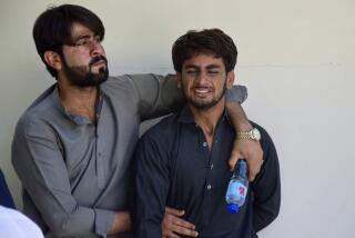 A man comforts another, who mourns over the death of his family member, killed by gunmen at a highway in Musakhail, at a hospital, in Quetta, Pakistan, Monday, Aug. 26, 2024. (AP Photo/Arshad Butt)