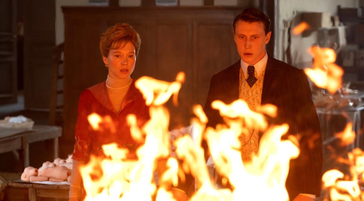 A woman and a man stare at a ball of flames