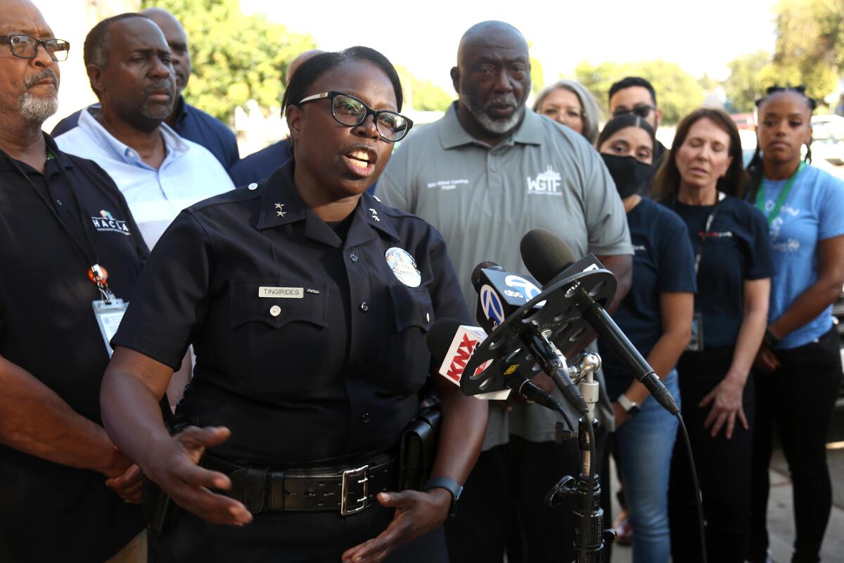 LAPD Deputy Chief Emada Tingirides speaks at a microphone.