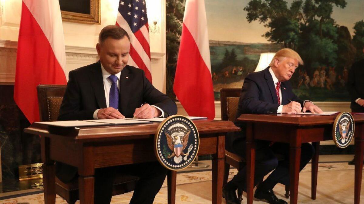 U.S. President Trump and Polish President Andrzej Duda sign a defense deal at the White House on Thursday.