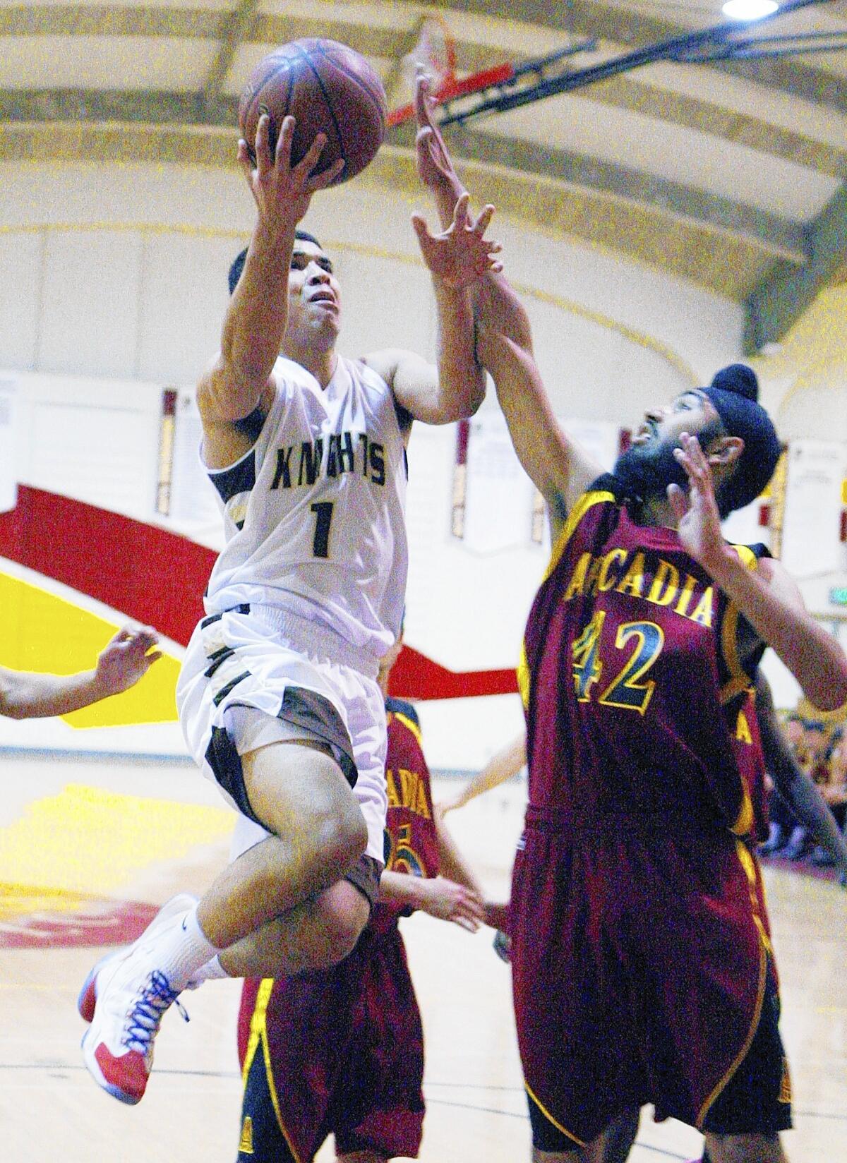 File Photo: St. Francis' Evan Crawford drives the lane to make a layup against Arcadia's Gagan Tut in the La Cañada Holiday Classic boys basketball tournament at La Cañada High School on Tuesday, Dec. 17, 2013.