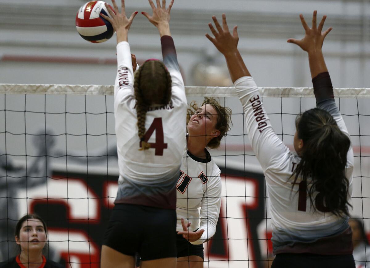 Huntington Beach's Haylee LaFontaine, center, battles at the net against Torrance in the Lakewood Molten Classic.