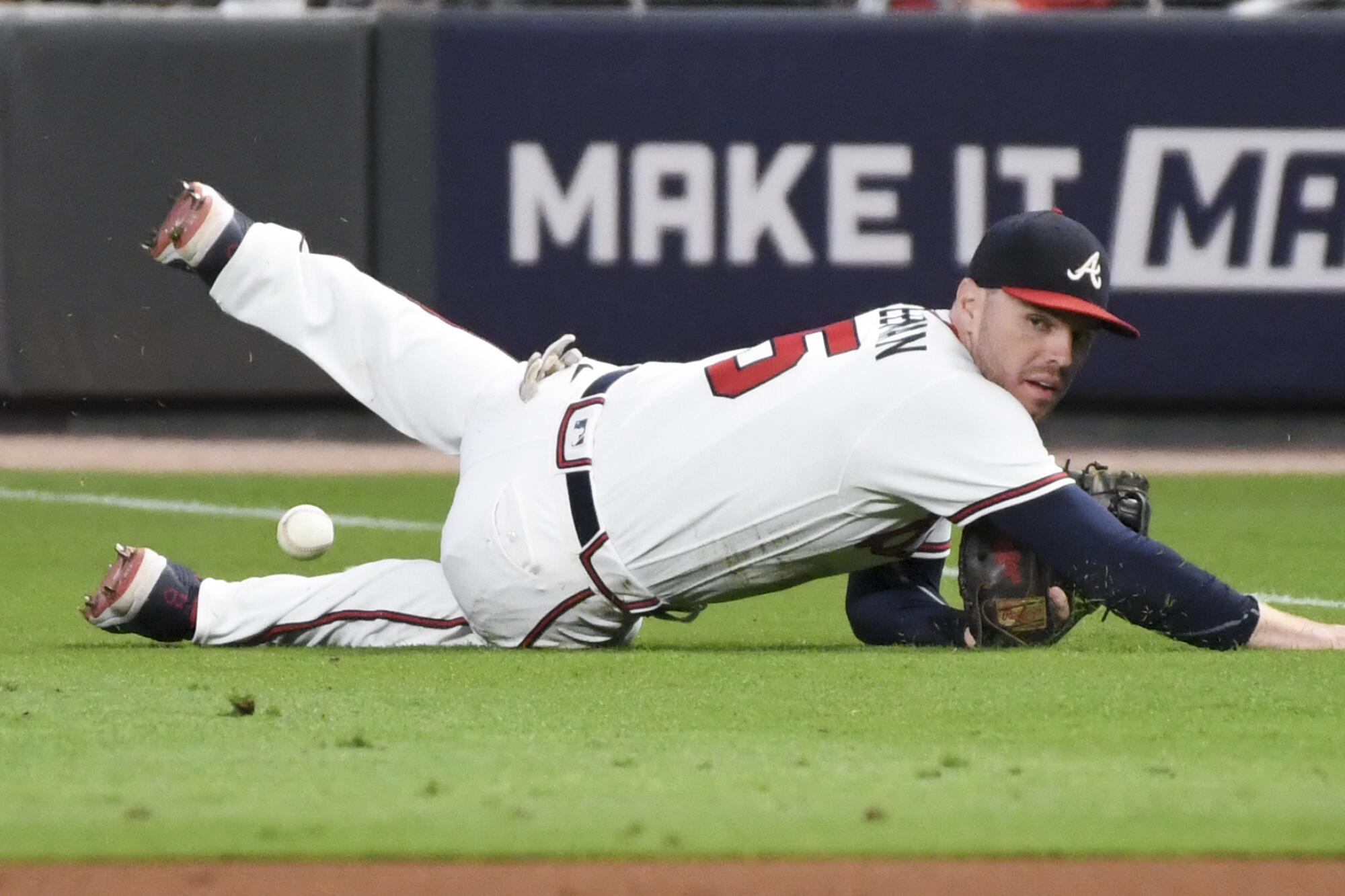 Braves first baseman Freddie Freeman can't make a catch on a pop up fly by Dodgers' Mookie Betts