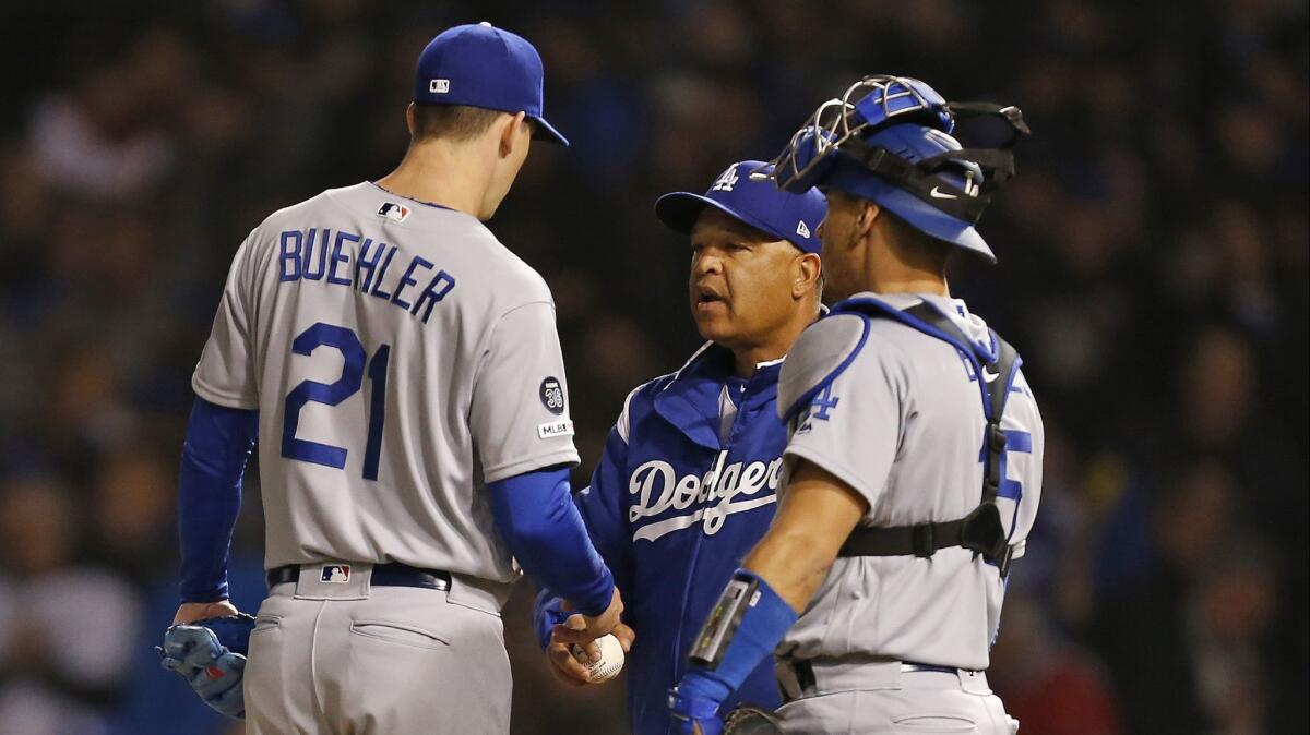 Dodgers pitcher Walker Buehler is removed by manager Dave Roberts during the sixth inning against the Chicago Cubs on Wednesday as catcher Austin Barnes joins in.