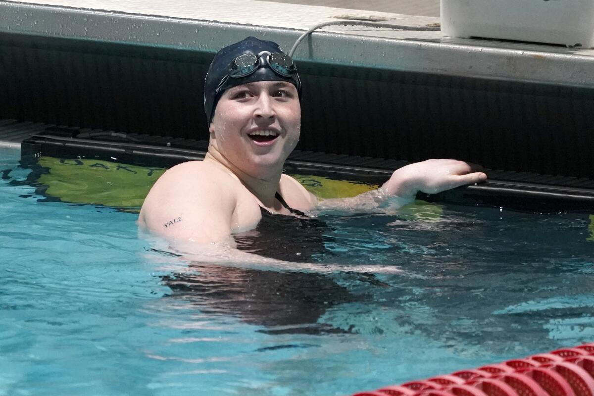 A trans man and competitive swimmer looks up after swimming.
