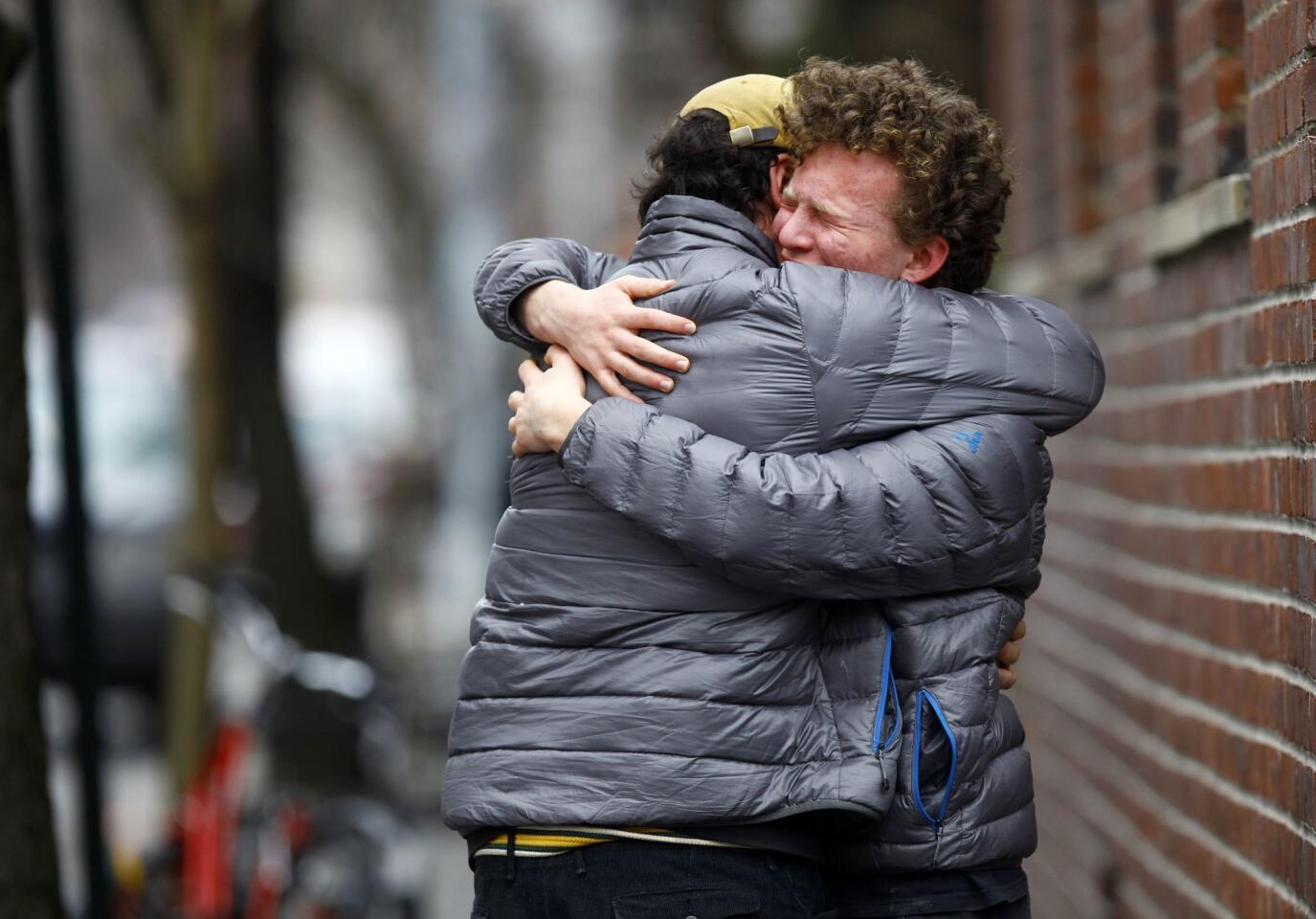 Two men embrace near the apartment where Philip Seymour Hoffman was found dead